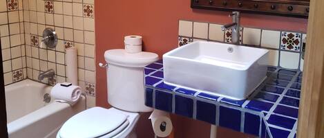A bathroom with a bathtub, toilet, sink, and shower.