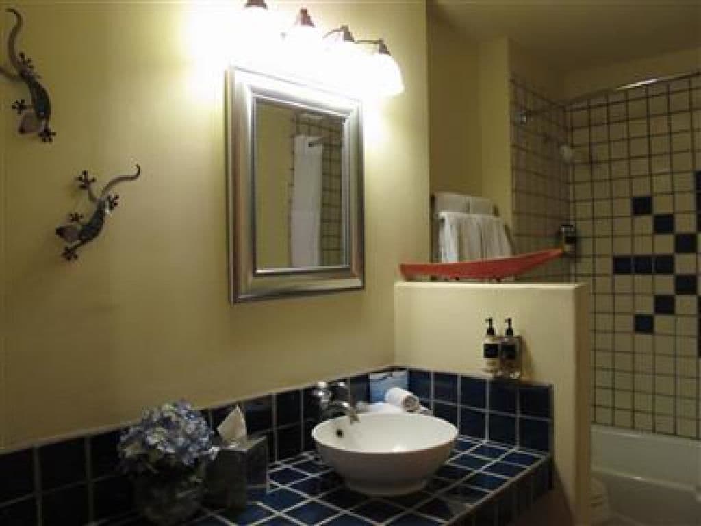 A bathroom with a sink, mirror, and tiled walls.