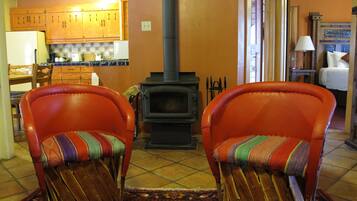A cozy living room with two leather armchairs, a fireplace, wooden cabinets, and a tiled floor.