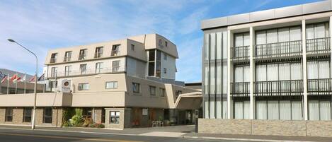 A hotel with a two-story building, a stone facade, and a balcony on the upper floor.