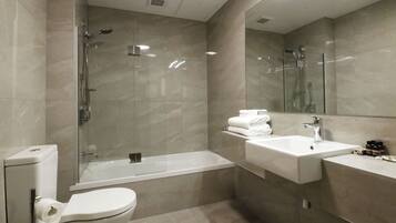 A modern bathroom with a toilet, a bathtub, a shower, and a sink.