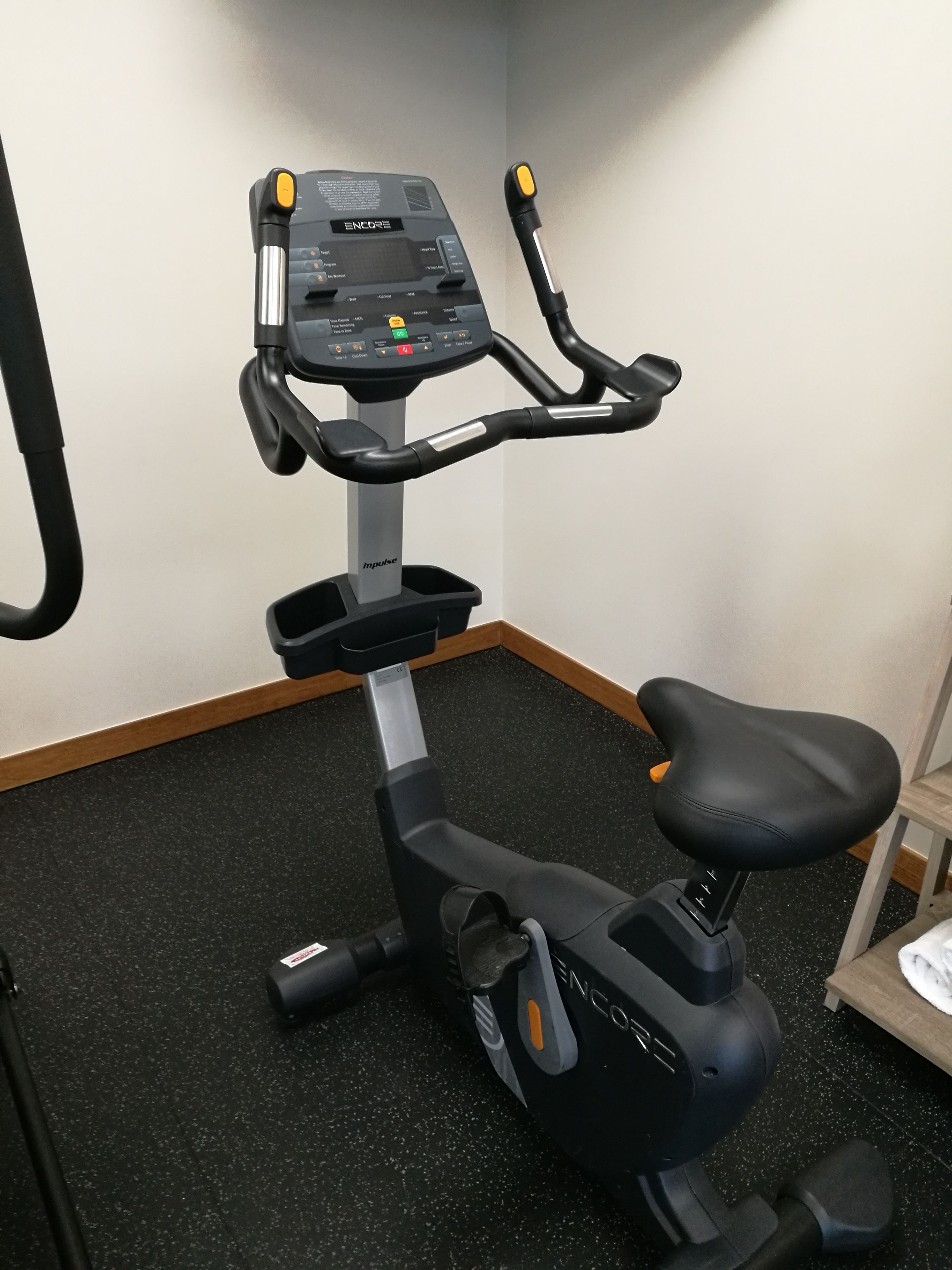 Una bicicleta estática con pantalla digital, panel de control y asiento.