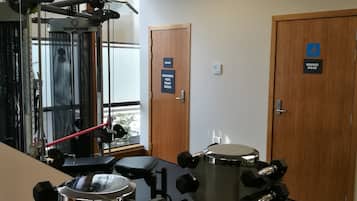 A gym with exercise equipment, a mirror, and doors labeled "Change Room".