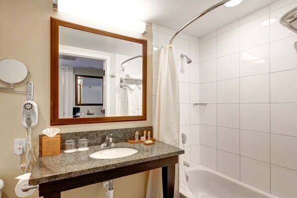 Un baño con lavamanos, espejo y ducha.