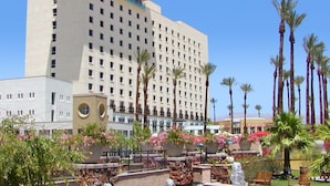 Un hôtel doté d’un grand bâtiment, d’une fontaine et de palmiers.