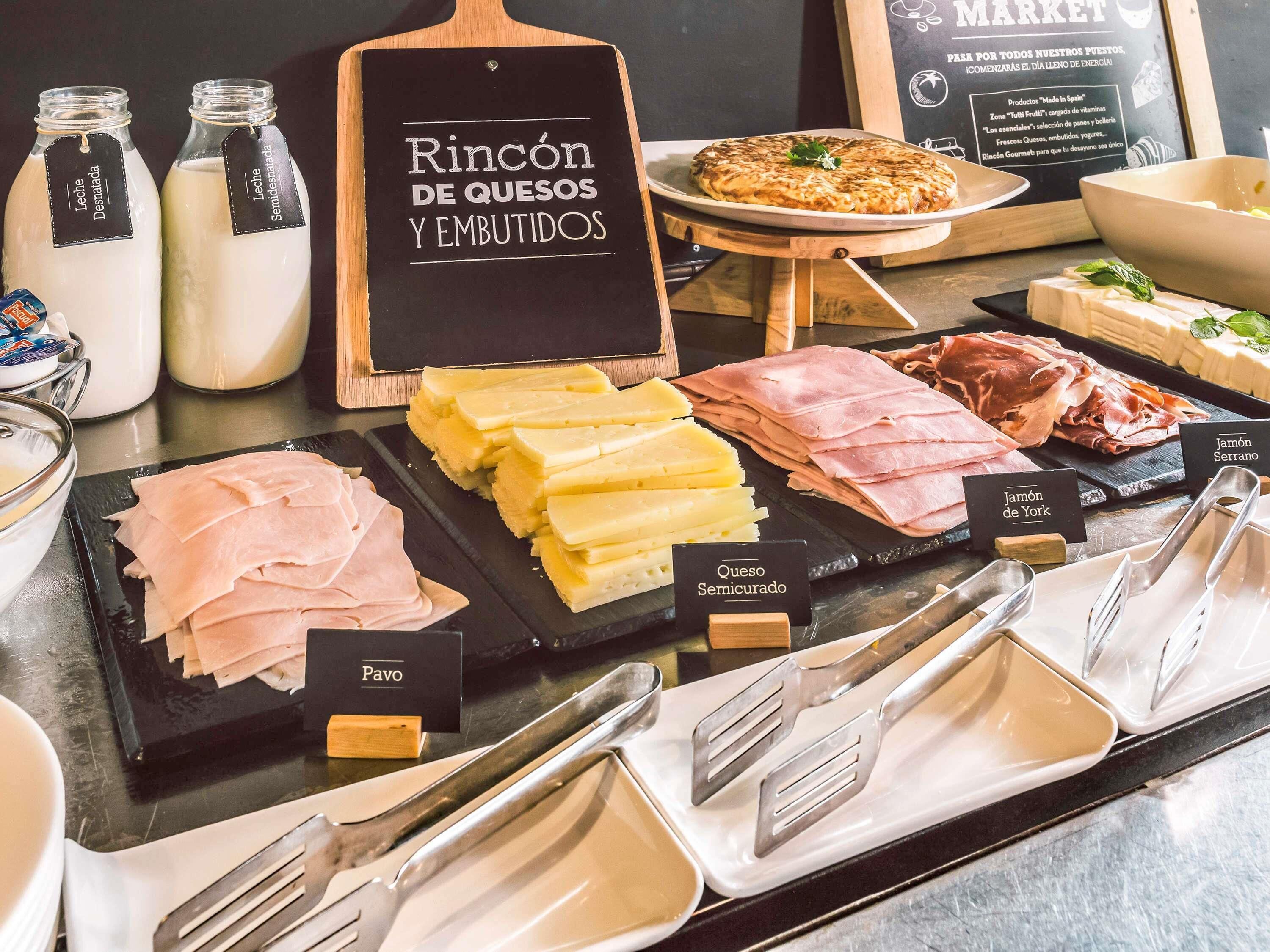Eine Platte mit Käse- und Fleischsorten, mit Beschriftungen für die verschiedenen Käse- und Fleischarten.