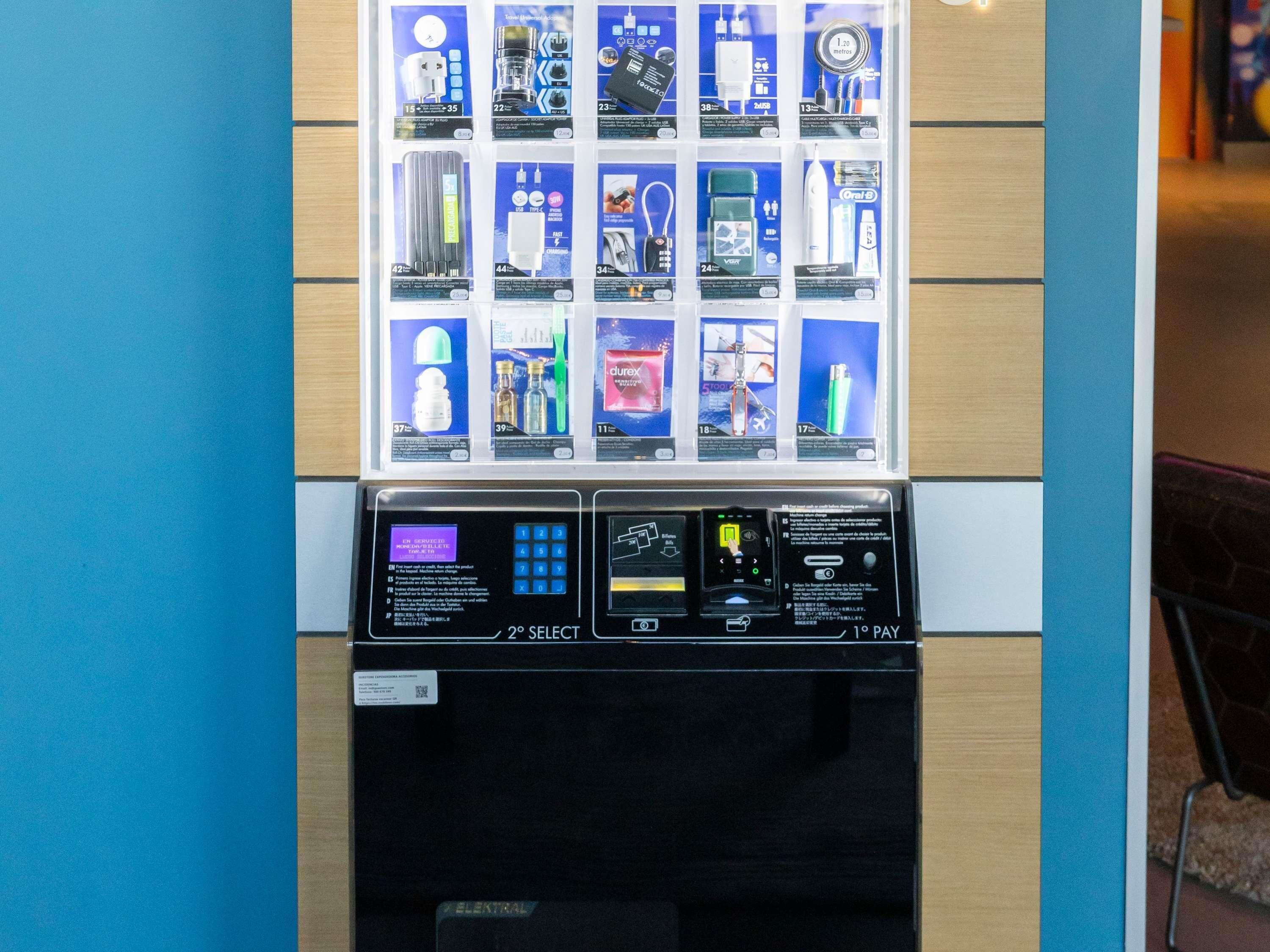 A vending machine with various products, including a coffee maker, a hair dryer, and a bottle of mouthwash.