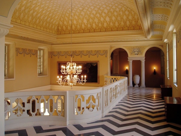 A grand room with a large chandelier, ornate ceiling, and a patterned floor. - Sina Villa Matilde (Romano Canavese)