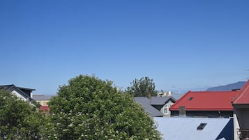 Zona residencial con casas, un árbol y un cielo azul despejado.