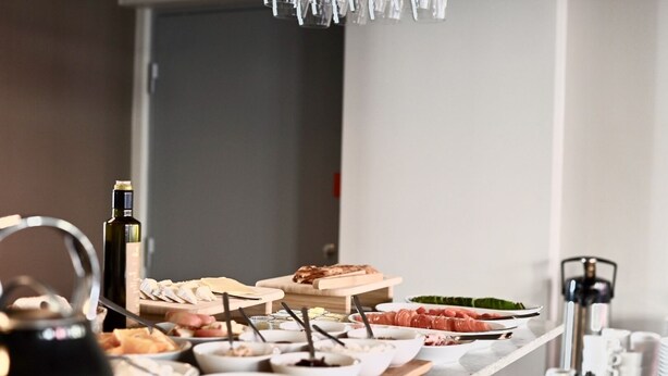 Una mesa de buffet con diversos alimentos y una botella de vino.