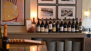 Un bar de vinos con una selección de botellas y fotografías enmarcadas en la pared.