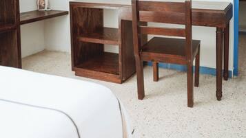 A corner of a room with a wooden chair and a small wooden table.