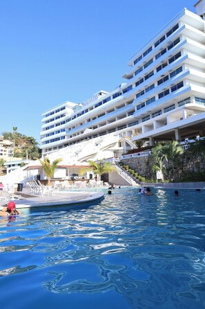 Un hôtel doté de nombreux balcons, d’une piscine et d’un escalier menant aux étages supérieurs.