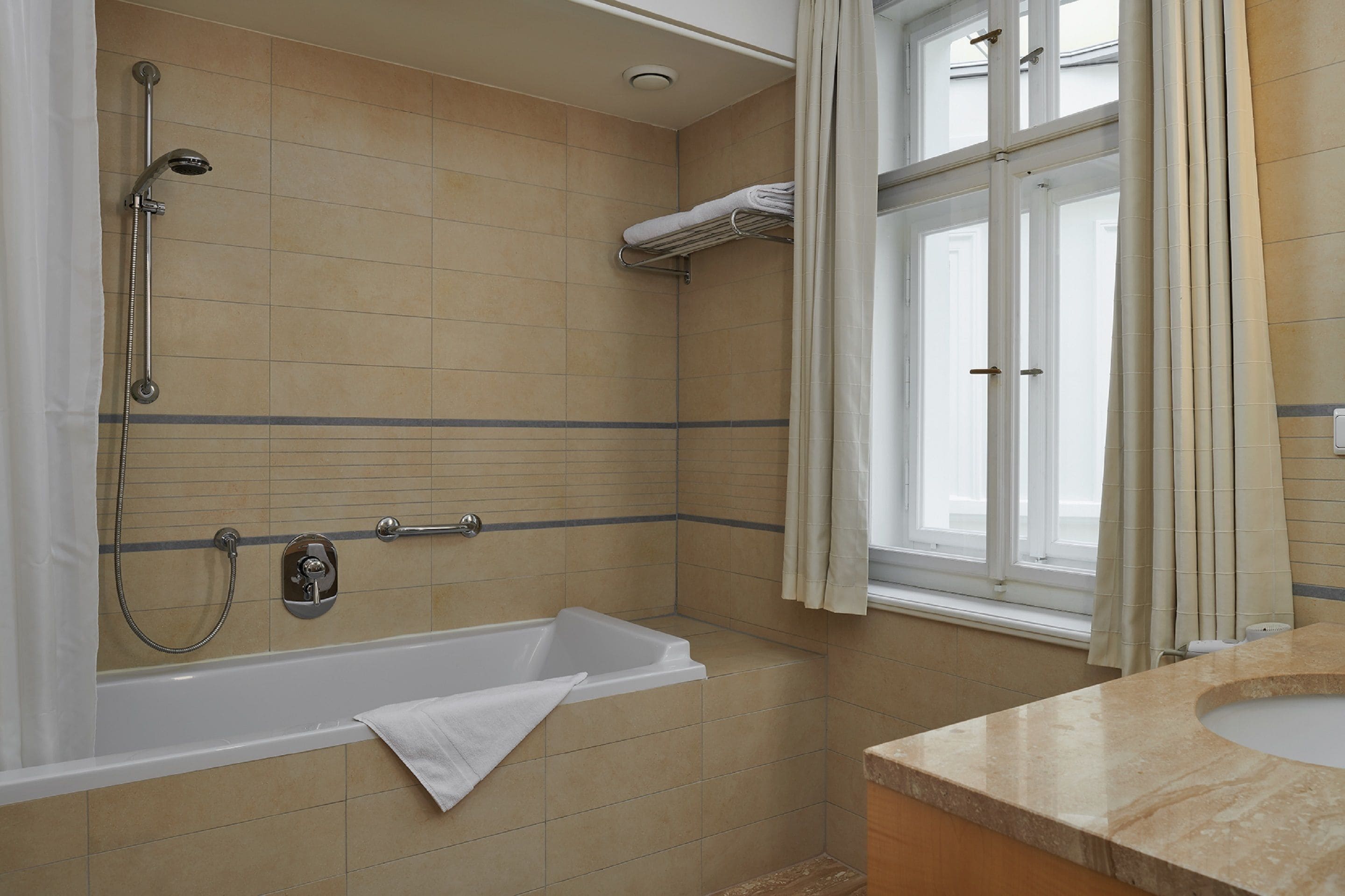 Un baño con bañera, ducha y ventana.