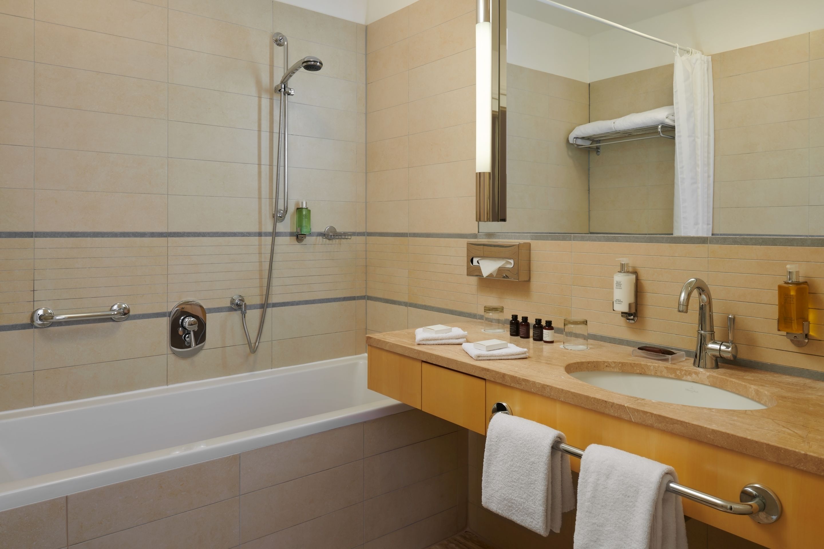 Un baño con bañera, lavabo, espejo y ducha.