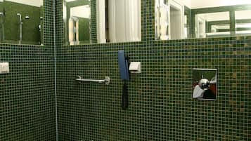 A bathroom with green mosaic tiles, a white sink, and a toilet.
