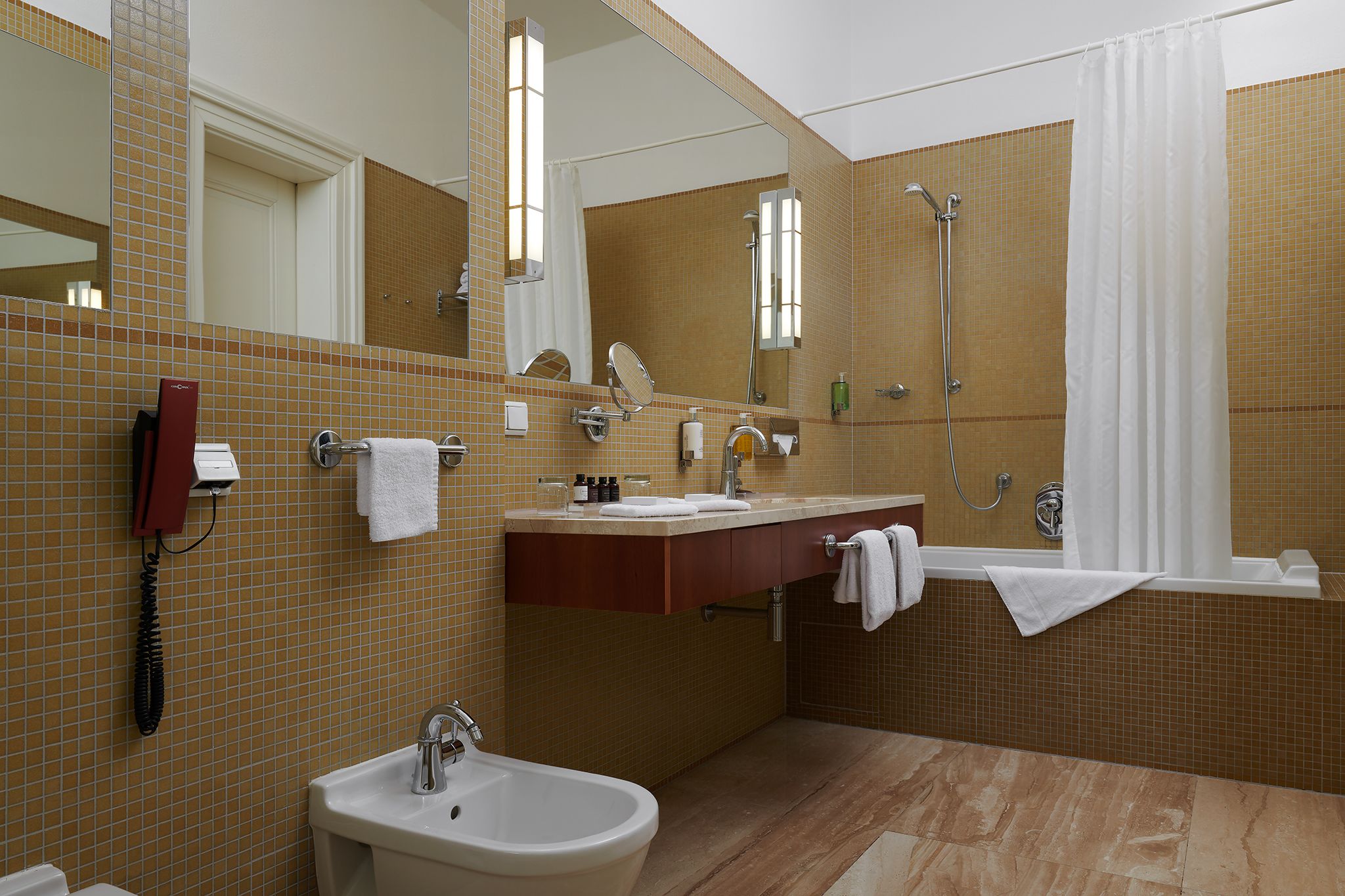 A modern bathroom with a sink, bidet, and shower.