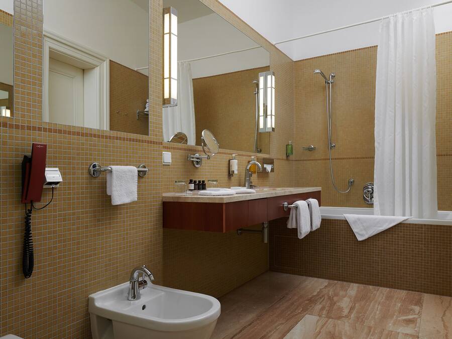 A modern bathroom with a sink, bidet, and shower.