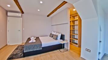 Un dormitorio moderno con cama, mesita de noche y estanterías empotradas.