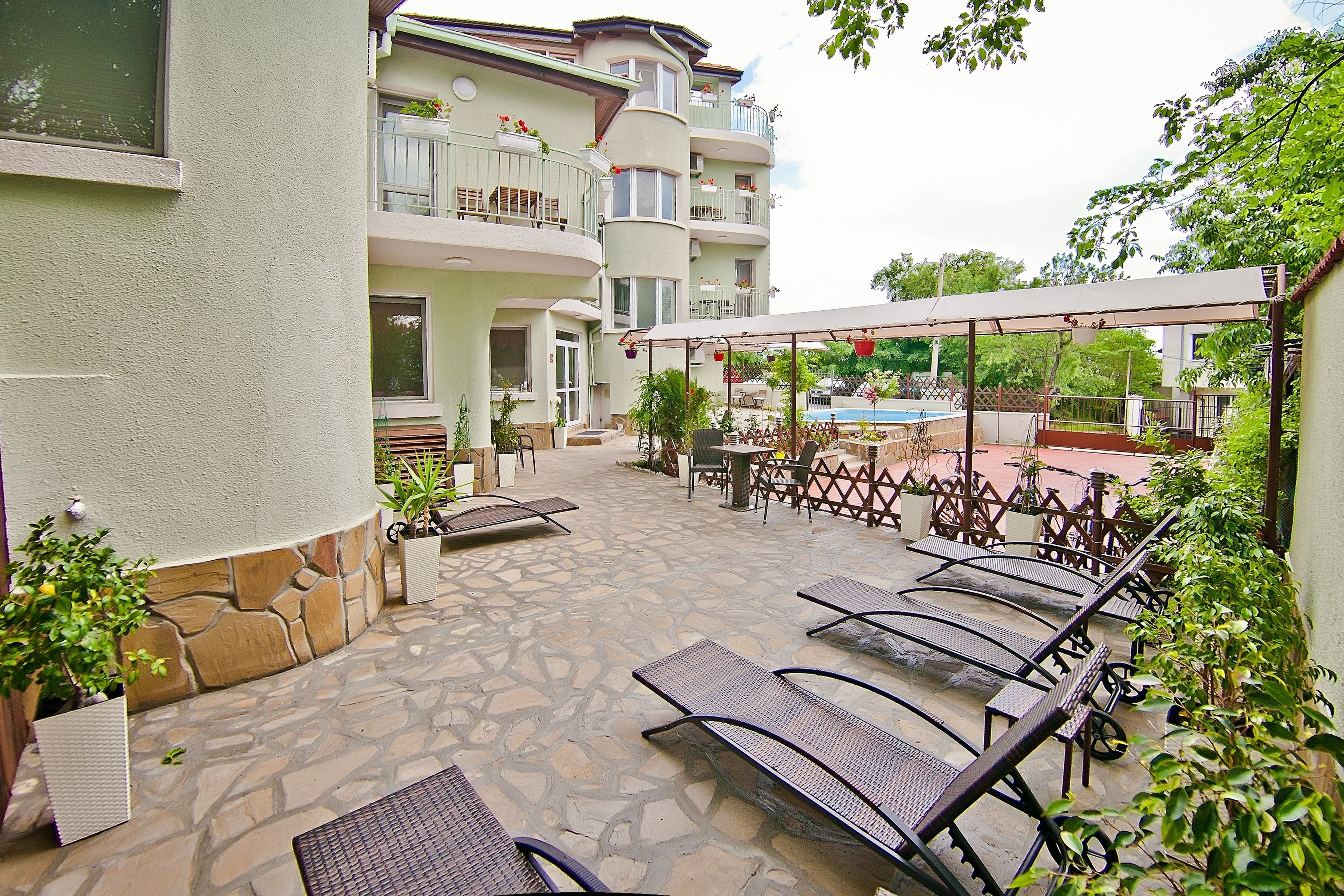 Une cour avec des espaces de détente en plein air, une piscine et un immeuble à plusieurs étages doté de balcons.