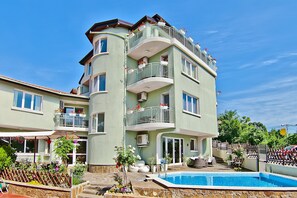 A multi-story building with balconies, a swimming pool, and a garden area. - Hotel Amfora (Varna)