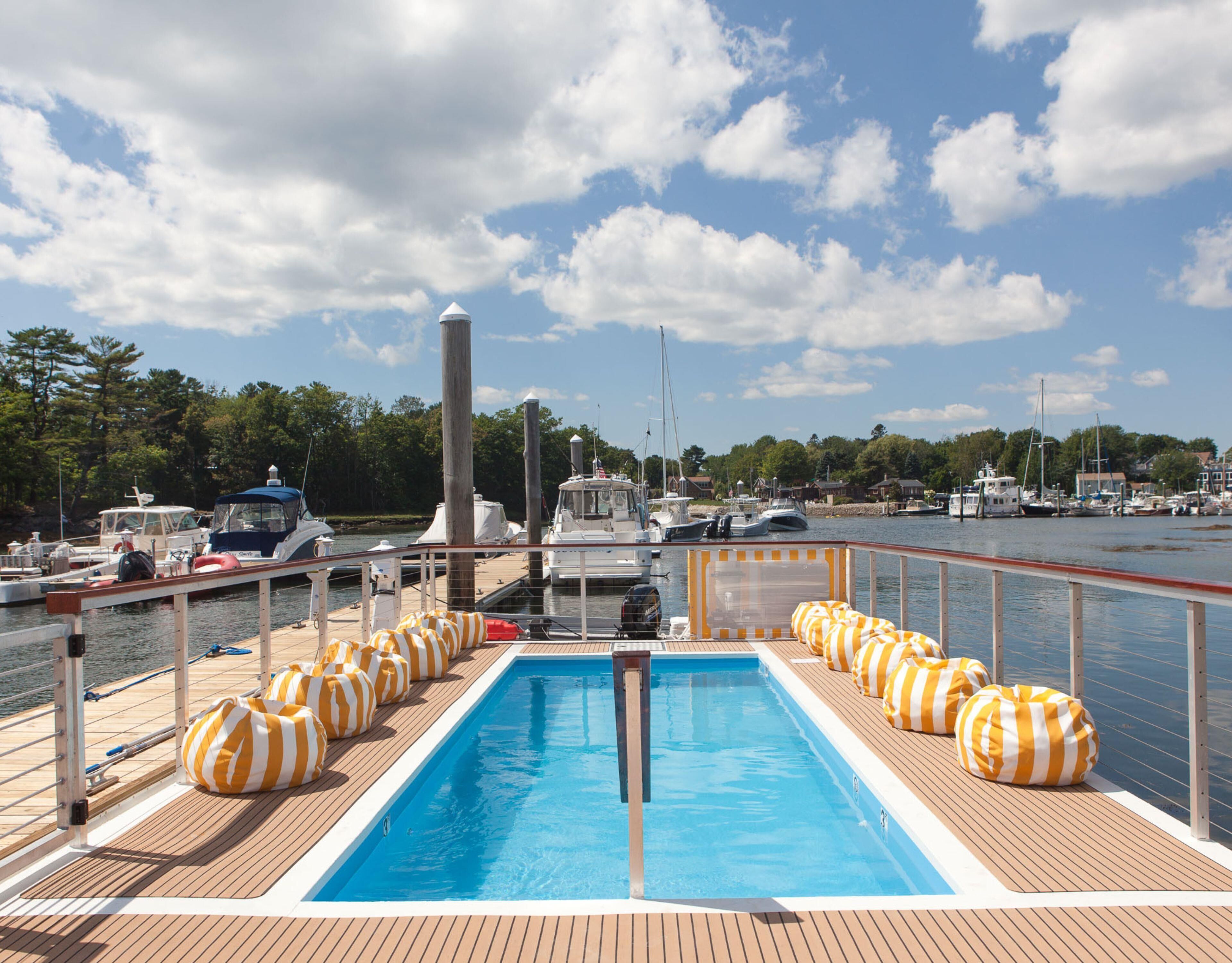 A pool area with loungers and a view of the marina.
