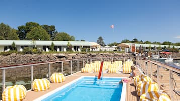 Zona de piscina con tumbonas, piscina y vistas de los edificios circundantes y el paisaje.