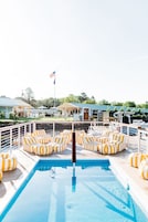 Una piscina al aire libre de temporada, sillones reclinables de piscina