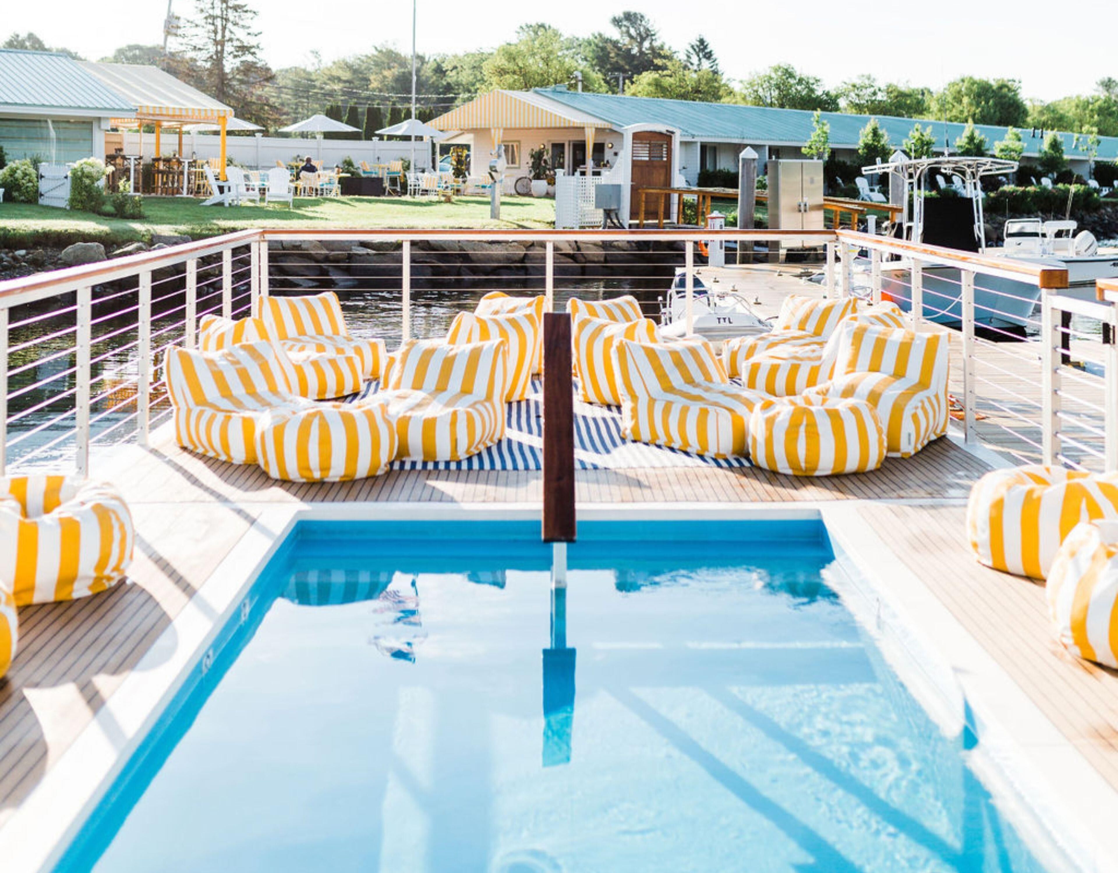 A pool area with striped cushions and a pool.
