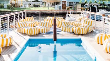 A pool area with striped cushions and a pool.