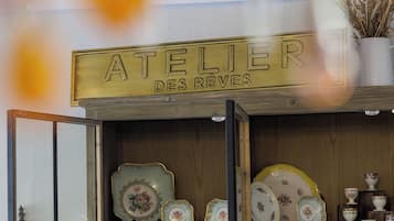 Una vetrina con utensili da cucina vintage e un cartello con su scritto 'ATELIER DES REVES'.