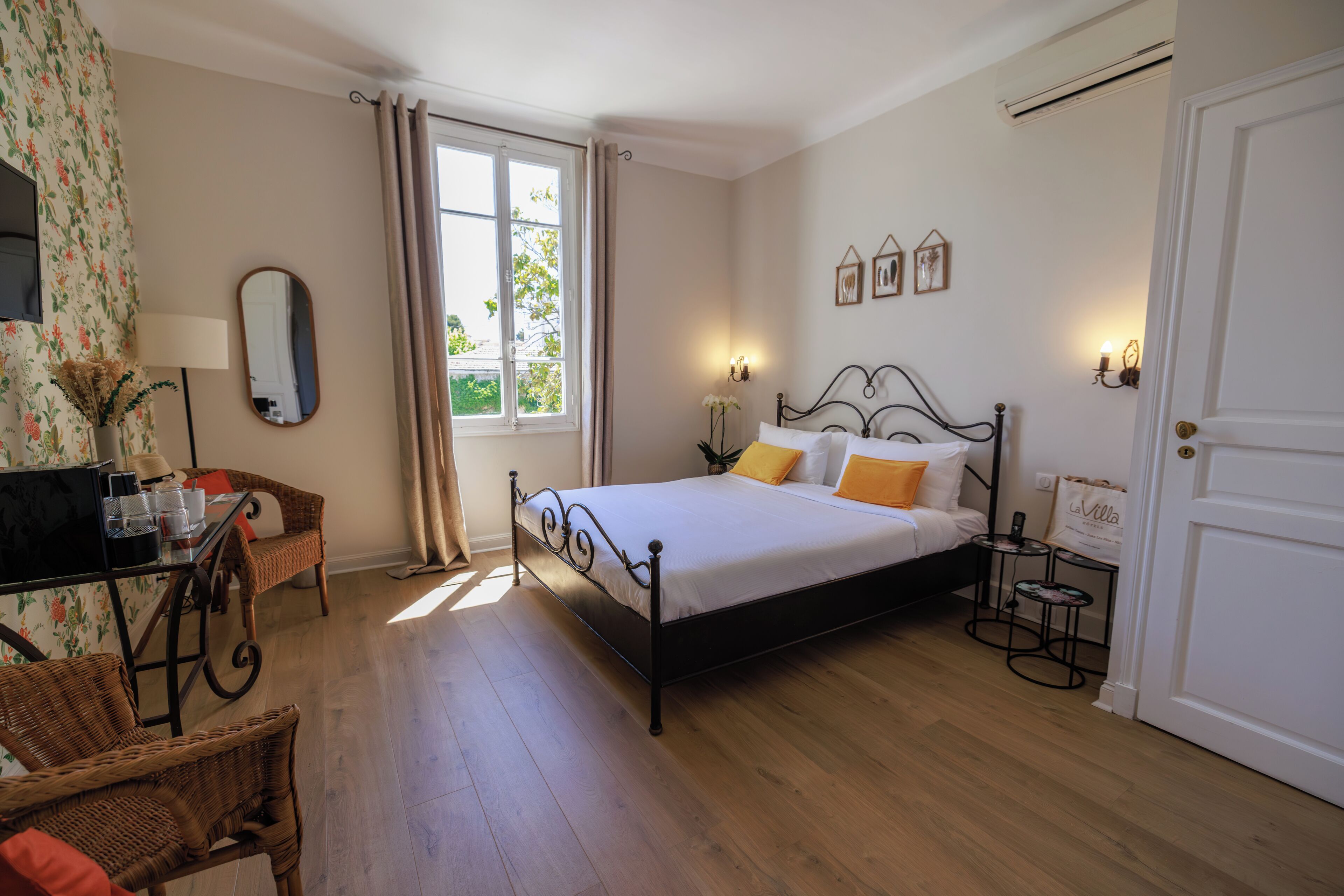 Un dormitorio con cama, escritorio, silla, ventana con cortinas y puerta.