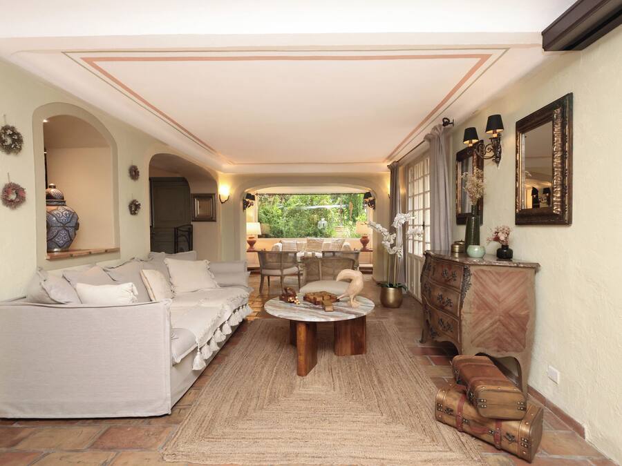 Amplia sala de estar con sofá, mesa de centro y comedor con mesa y sillas.