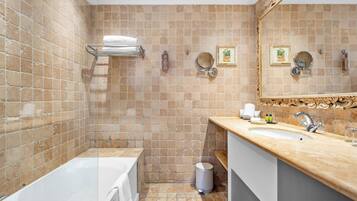 Ein Badezimmer mit Badewanne, Waschbecken und Spiegel.