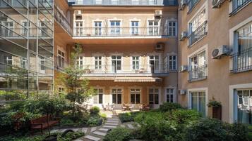 Een binnentuin met een centraal gelegen zitgedeelte, omringd door gebouwen met balkons en airconditioners.