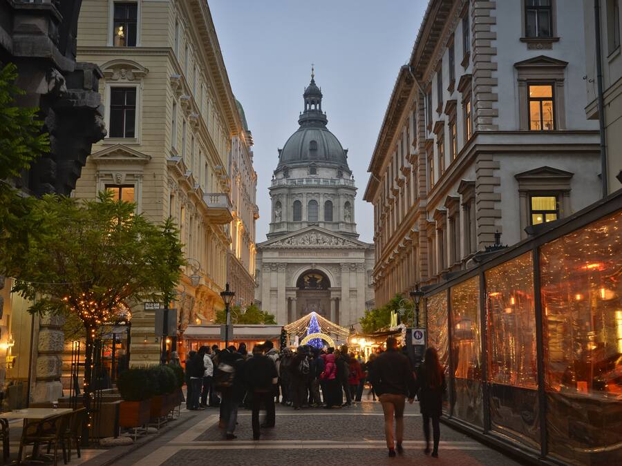 Una calle con edificios históricos, una estructura con cúpula y un mercado navideño.