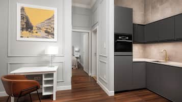 A modern kitchen with grey cabinets, a stainless steel oven, and a gold faucet.
