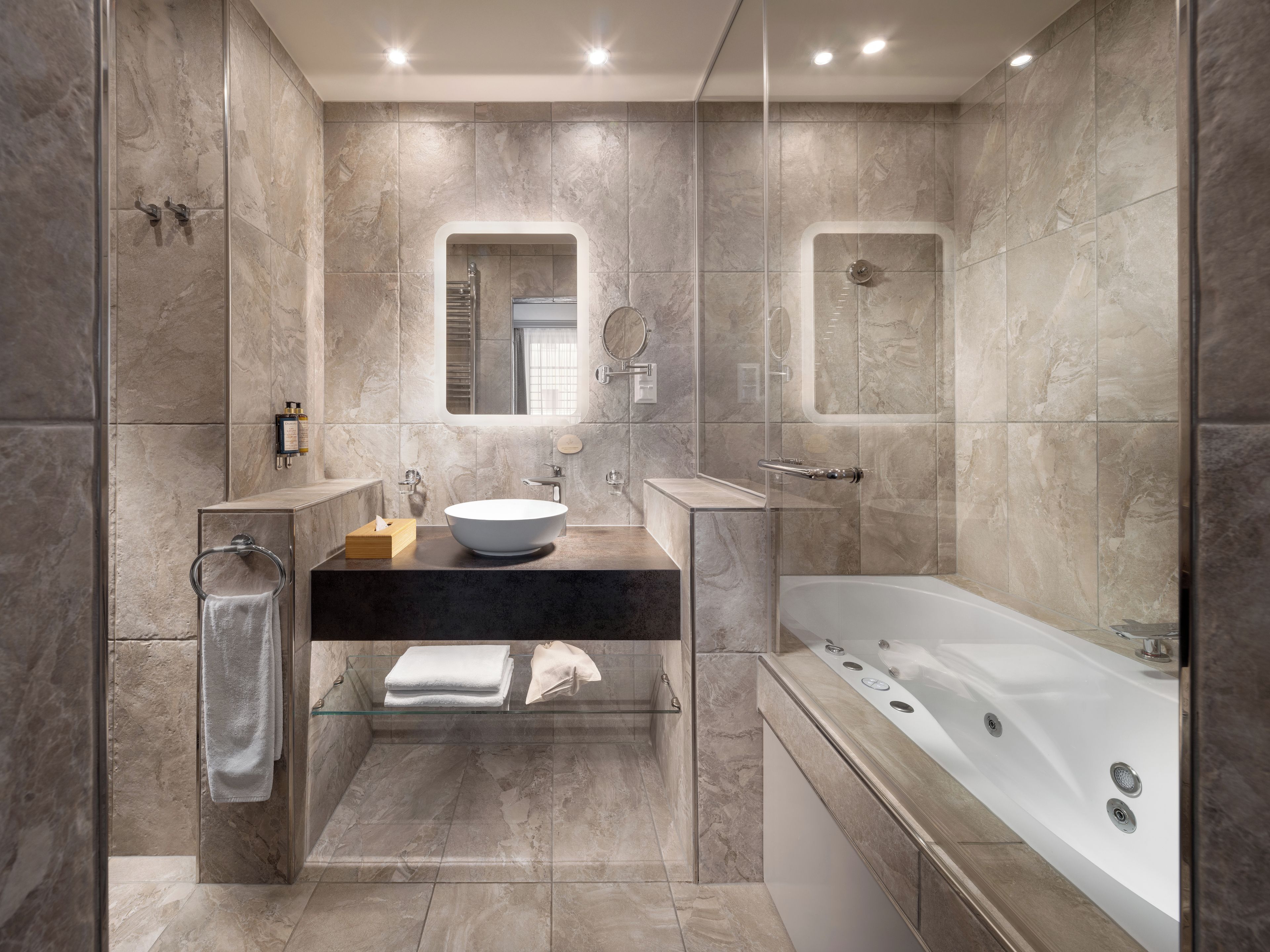 A modern bathroom with a freestanding bathtub, a glass-enclosed shower, and a vanity with a sink and mirror.