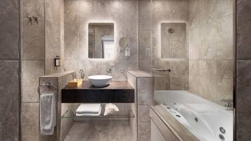 A modern bathroom with a freestanding bathtub, a glass-enclosed shower, and a vanity with a sink and mirror.