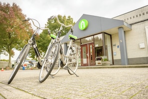 Zwei Fahrräder stehen vor einem Gebäude mit grünem Logo und der Nummer 5 an der Wand.