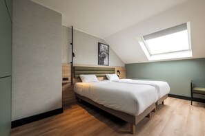A modern bedroom with a bed, a skylight, and a wall-mounted artwork. - TULIP Hotels & Residences - Zwolle (Zwolle)