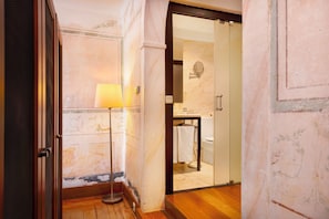 Ein Hotelbad mit Duschkabine aus Glas, Waschbecken und Spiegel.