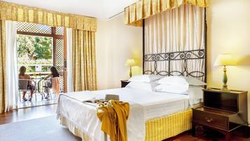 A hotel room with a bed, bedside tables, a window with curtains, and a view of the outside.