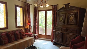 A cozy living room with a sofa, a wooden cabinet, and a table with a lamp.