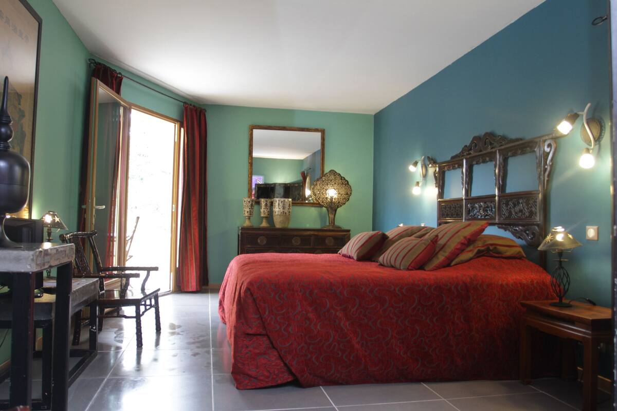 Une chambre à coucher avec un grand lit, une commode, un bureau et une chaise.