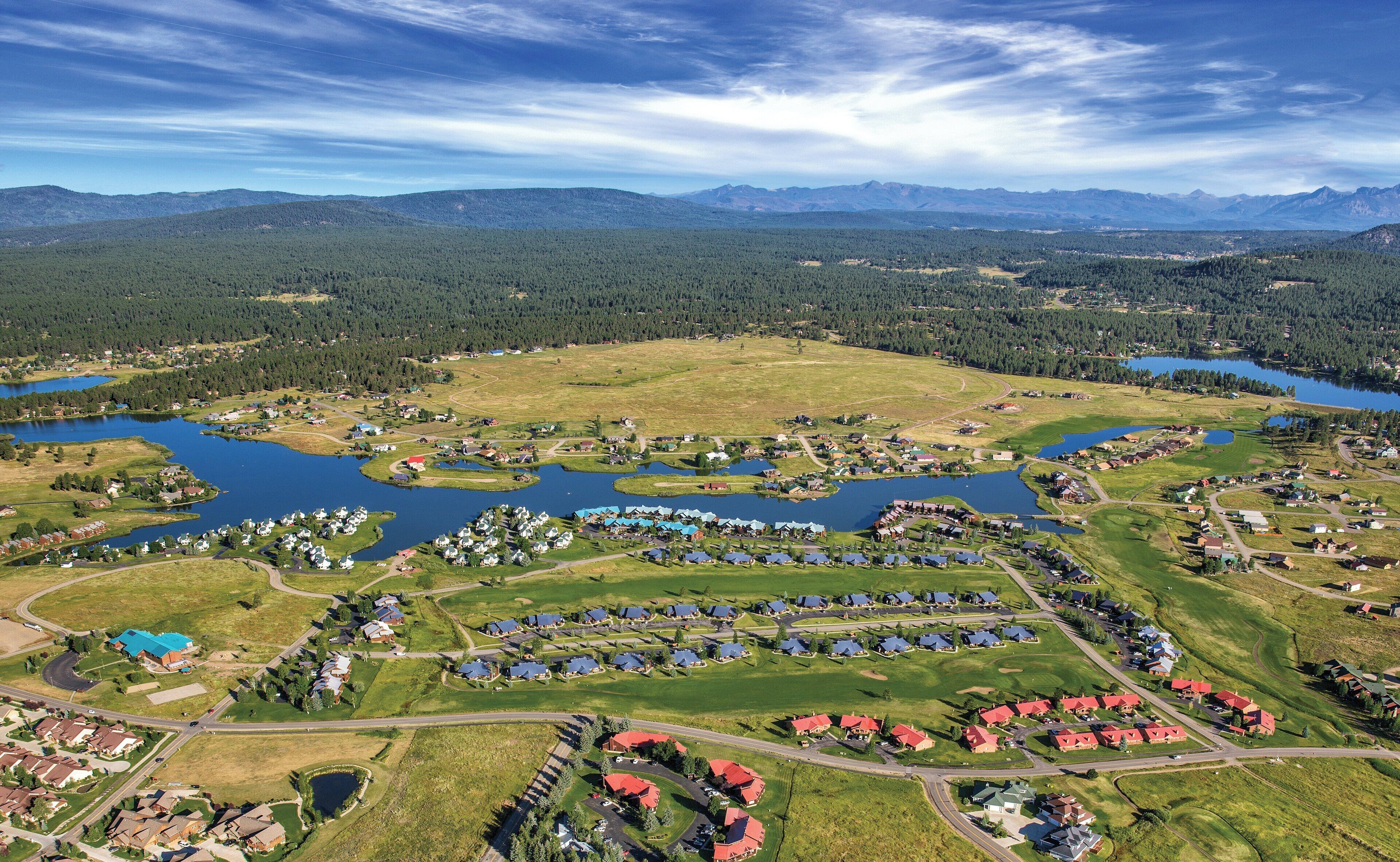Zona residencial con casas, caminos y un lago.