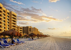 On the beach, white sand, sun loungers, beach umbrellas