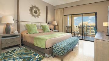 A hotel room with a large bed, a balcony with a view, a desk, and a chair.