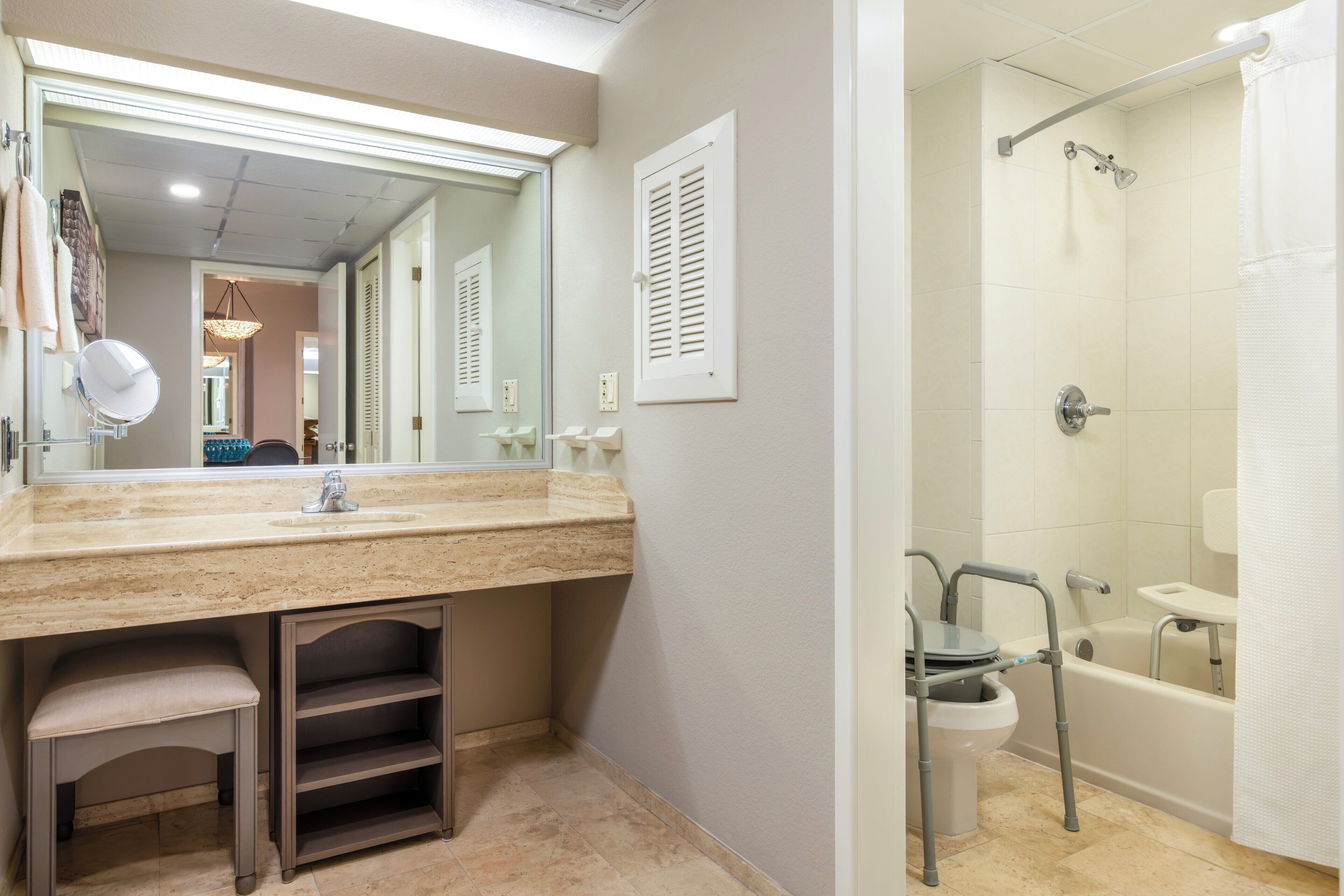 A bathroom with a sink, mirror, shower, and toilet.