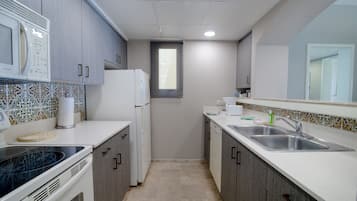Una cocina moderna con microondas, estufa, fregadero y refrigerador.